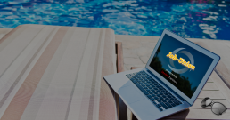 Laptop am Pool mit Job-Union Logo und Sonnenbrille